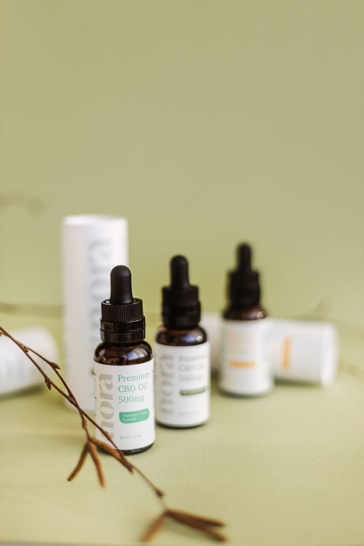 Frascos premium de aceite CBD sobre fondo verde